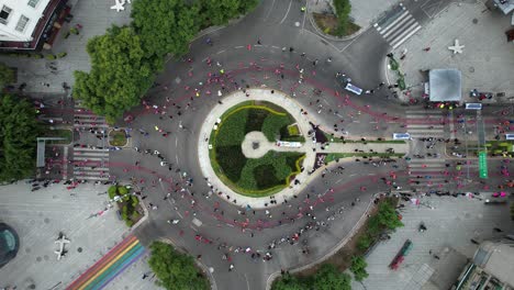 Landungsdrohnenaufnahme-Von-Läufern-Beim-Maraton-De-La-Ciudad-De-Mexico,-Die-Einen-Kreisverkehr-Passieren