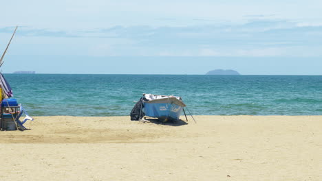 A-foreign-tourist-is-strolling-from-the-right-to-the-left-side-of-the-frame,-at-Pattaya-Beach-with-the-Gulf-of-Thailand-and-some-islands-in-the-background-at-Chonburi-province-in-Thailand