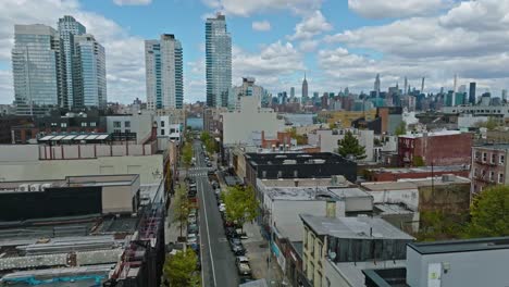 Descending-drone-shot-showing-streets-of-Greenwich-district-with-american-neighborhood-and-Manhattan-in-Background