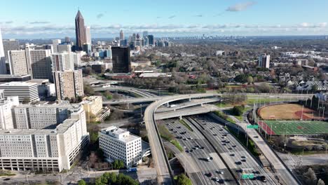 Vista-Panorámica-Del-Tráfico-Del-Cruce-De-Autopistas-Interestatales-Del-Centro-De-Atlanta,-Paso-Elevado-Con-Paisaje-Urbano-Moderno,-Aéreo