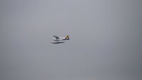 A-Single-Engine-Beaver-Seaplane-Flying-with-an-Overcast-Sky-Background