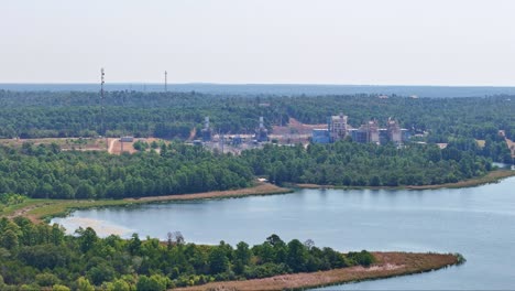 Moving-slowly-to-the-left-above-a-small-peninsula-and-a-large-lake-inlet-that-has-a-power-plant-behind-it