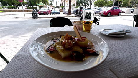 Close-up-shot-of-traditional-seafood-with-mussels,-king-prawns-and-squids-on-an-outdoor-restaurant-table
