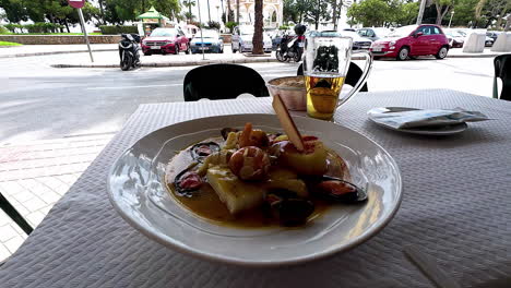 Primer-Plano-De-Mariscos-Tradicionales-Con-Mejillones,-Langostinos-Y-Calamares-En-Una-Mesa-De-Restaurante-Al-Aire-Libre