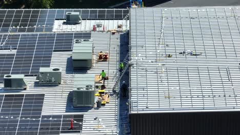 Arbeiter-Eines-Solarpanel-Installationsunternehmens-Auf-Einem-Industriedach-Aus-Metall