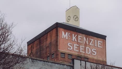 Tiefwinkelaufnahme-Des-Bewölkten-Herbstes-Des-Alten,-Historischen-Landwirtschaftsturms,-Des-Mckenzie-Seeds-Gebäudes-In-Der-Innenstadt-Von-Brandon,-Manitoba,-Kanada