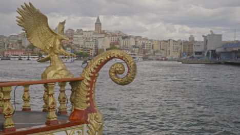 Torre-De-Gálata-Desde-El-Muelle-De-Eminonu-Con-Mascarón-De-Proa-Dorado-Del-Fish-Boat-Cafe