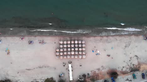 Drohnenansicht-Von-Oben-Nach-Unten-Strandbar-Sonnenschirme-Sonnenuntergang-Sommer