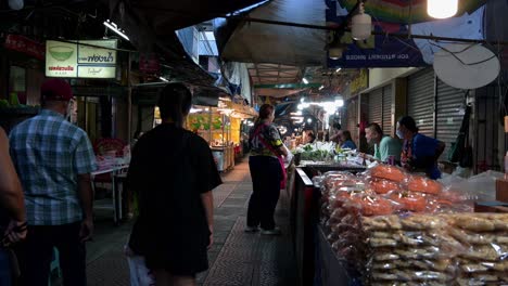 Turistas-Locales-Y-Extranjeros-En-Un-Recorrido-Nocturno-Por-La-Calle-Peatonal-Del-Mercado-Nocturno-Flotante-De-Amphawa,-En-Busca-De-Algunos-Recuerdos-Y-Comida-Para-Comer.