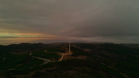 Aerial-dolly-shot-of-an-electric-wind-turbine-for-environmental-renewable-energy-in-tarifa,-Observatorio-ornitologico-el-cabrito-in-spain-at-golden-hour