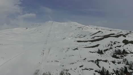 Eine-Luftaufnahme-Einer-Klaren-Weißen-Schneelandschaft-Auf-Einem-Berg-Bei-Leicht-Bewölktem-Wetter-In-Österreich