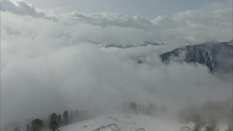 Una-Vista-Aérea-De-Un-Paisaje-Nevado-Cubierto-De-Niebla-En-Un-Clima-Nublado-En-Austria
