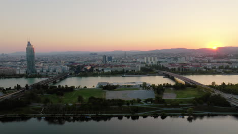 Donauinsel-man-made-island-in-Danube-river,-cinematic-view-of-Vienna-skyline-behind-at-sunset