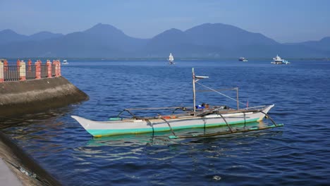 El-Omnipresente-Tono-Azul-Bajo-El-Sol-De-La-Mañana-Saluda-A-Un-Pequeño-Barco-Pesquero-Amarrado-En-La-Costa-De-La-Ciudad-De-Puerto-Princesa,-Capital-De-Palawan,-Filipinas