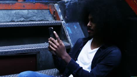 Hombre-Afro-Sentado-En-Las-Escaleras-Y-Usando-Teléfono-Móvil,-4k-4k