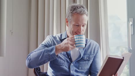 Man-reading-a-book-while-having-coffee-4k