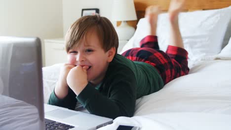 Boy-using-laptop-in-bedroom-4k