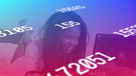 Multiple-changing-numbers-against-african-american-woman-smiling-while-using-laptop