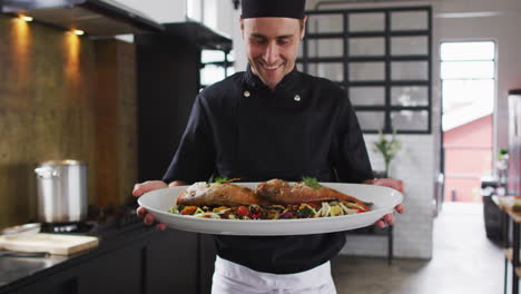 Caucasian-male-chef-preparing-a-dish-and-smiling-in-a-kitchen-