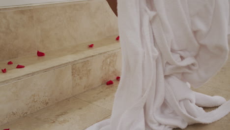 Mixed-race-woman-walking-into-a-bathtub-at-home