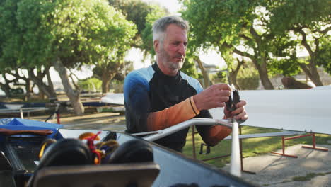 Senior-caucasian-man-preparing-rowing-boat-for-the-water