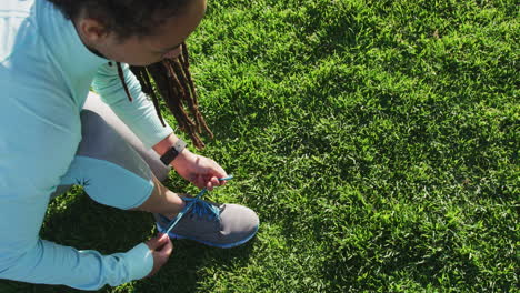 Mujer-Afroamericana-En-Ropa-Deportiva-Atándose-Los-Cordones-De-Los-Zapatos-En-El-Parque