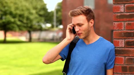 Happy-student-talking-on-the-phone-outside