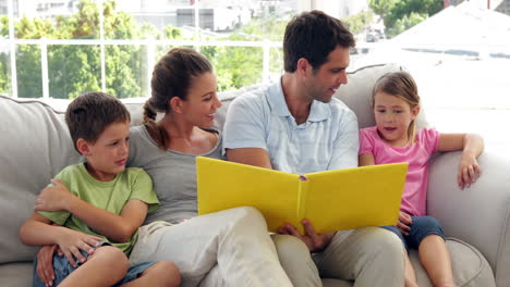 Cute-family-relaxing-together-on-the-couch-looking-at-photo-album