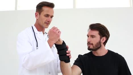 Doctor-checking-on-injured-patient-in-a-wrist-brace