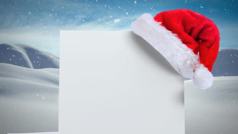 Animation-of-blank-card-with-copy-space-and-santa-hat-over-snow-falling-and-winter-scenery