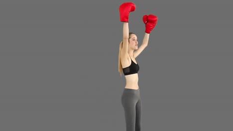 Fit-model-cheering-with-red-boxing-gloves