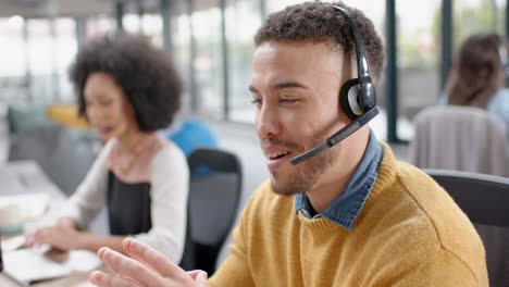 Porträt-Eines-Glücklichen-Gemischtrassigen-Geschäftsmannes,-Der-Im-Büro-über-Ein-Telefon-Headset-Spricht