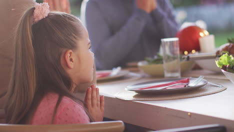 Video-Einer-Glücklichen-Kaukasischen-Tochter,-Die-Vor-Dem-Familienessen-Am-Tisch-Gnade-Sagt