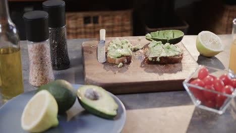 Close-up-of-avocado-toast,-vegetables-and-juice-in-kitchen,-slow-motion