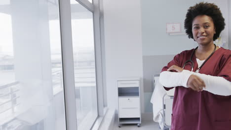 Portrait-of-happy-african-american-female-doctor-in-hospital-room-with-copy-space,-slow-motion