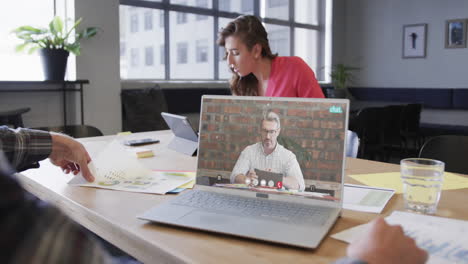 Caucasian-businessman-on-laptop-video-call-with-caucasian-male-colleague-on-screen