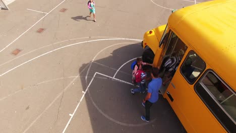 Teacher-giving-high-to-kids-while-entering-in-bus