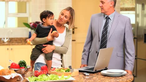 Couple-in-kitchen-with-baby-and-laptop-