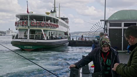 Un-Pescador-Y-Su-Esposa-Conversan-En-El-Muelle-De-Eminonu-Mientras-El-Ferry-Público-Sale-Del-Muelle.