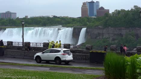 Static-shot-of-niagara-falls-a-popular-tourist-destination-near-new-york-and-the-canadian-province-of-ontario-with-view-of-the-waterfall,-tourists-and-a-busy-road-in-slow-motion