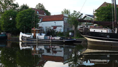 Ankernde-Schiffe-Mit-Spiegelung-über-Dem-Wasser-Im-Alten-Hafen-Von-Gouda,-Niederlande