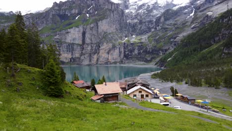Lago-Alpino-Oeschinen-Y-Restaurante-Del-Hotel-De-Montaña-En-Medio-De-Los-Alpes-Suizos-En-Kandersteg,-Suiza