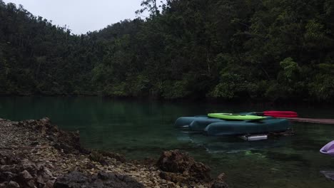 Canoes-and-SUP-paddle-boards-on-raft-at-water-shore-of-tropical-Sugba-Lagoon,-Siargao