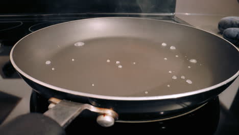 Water-splashed-onto-teflon-pan,-evaporating-fast