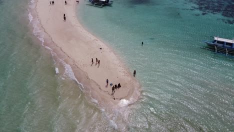 People-on-Ditaytayan-island-sandbar-with-escapade-Tour-Boats-on-clear-blue-water,-coron