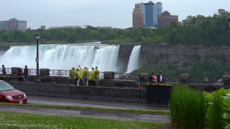 Static-slow-motion-shot-of-niagara-falls-a-beautiful-tourist-destination-near-new-york-and-the-canadian-province-of-ontario-with-view-of-the-waterfall,-tourists-and-a-busy-road