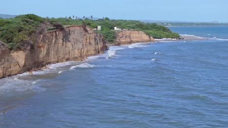Drone-shot-showing-beautiful-coastline-with-steep-cliffs-and-splashing-waves-of-Caribbean-sea