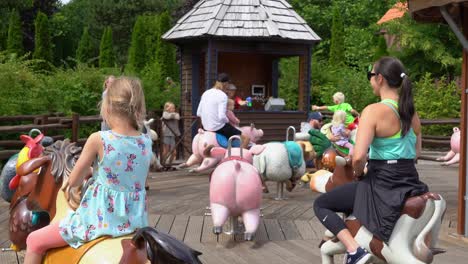 Niños-Felices-En-El-Tradicional-Carrusel-Familiar-Con-Animales-De-Granja-En-El-Parque-De-Atracciones-Djurs-Dinamarca