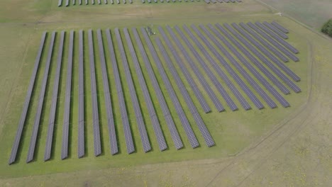 Shadow-of-clouds-covers-huge-solar-cell-park-in-rows-on-a-green-farming-field