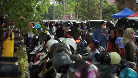 Crowded-street-of-people-and-motorbikes-in-Indonesia,-handheld-view
